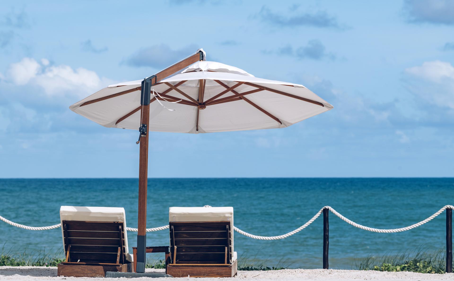 Two lounge chairs with a sun umbrella on the beach – what you need to pack for a perfect beach day in Brazil.