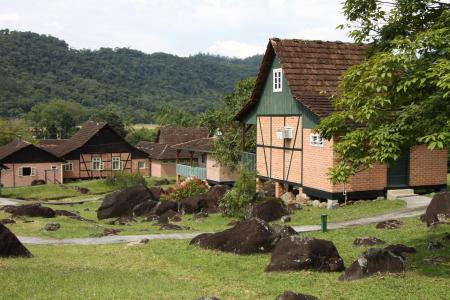 Traditional half-timbered houses in a lush green landscape in Santa Catarina, Brazil, reflecting the region's German heritage.