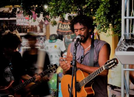 Brazilian musician playing guitar during a live performance