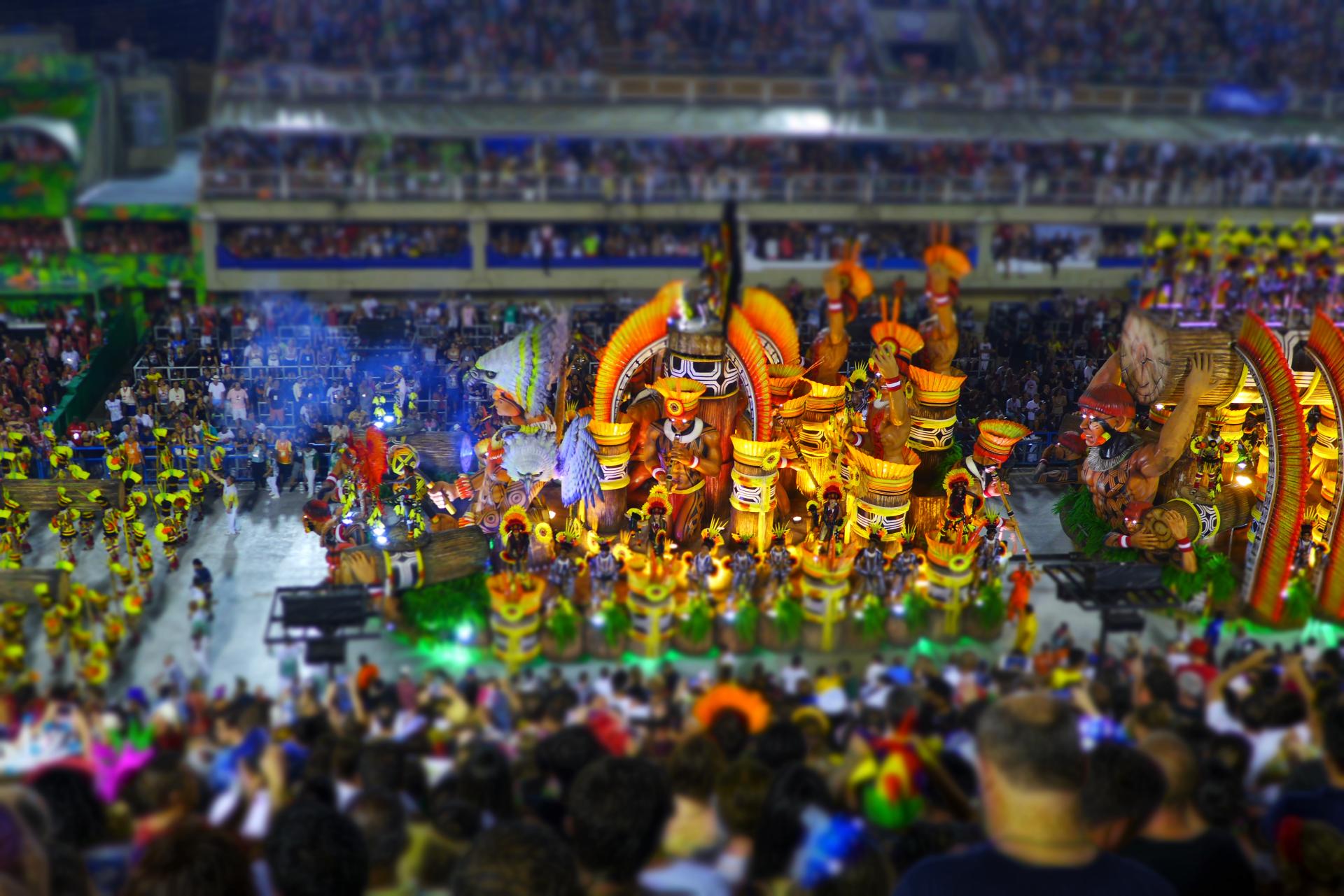 Colorful Carnival parade at the Sambódromo in Rio de Janeiro with elaborate floats, dancers in vibrant costumes, and a cheering crowd.