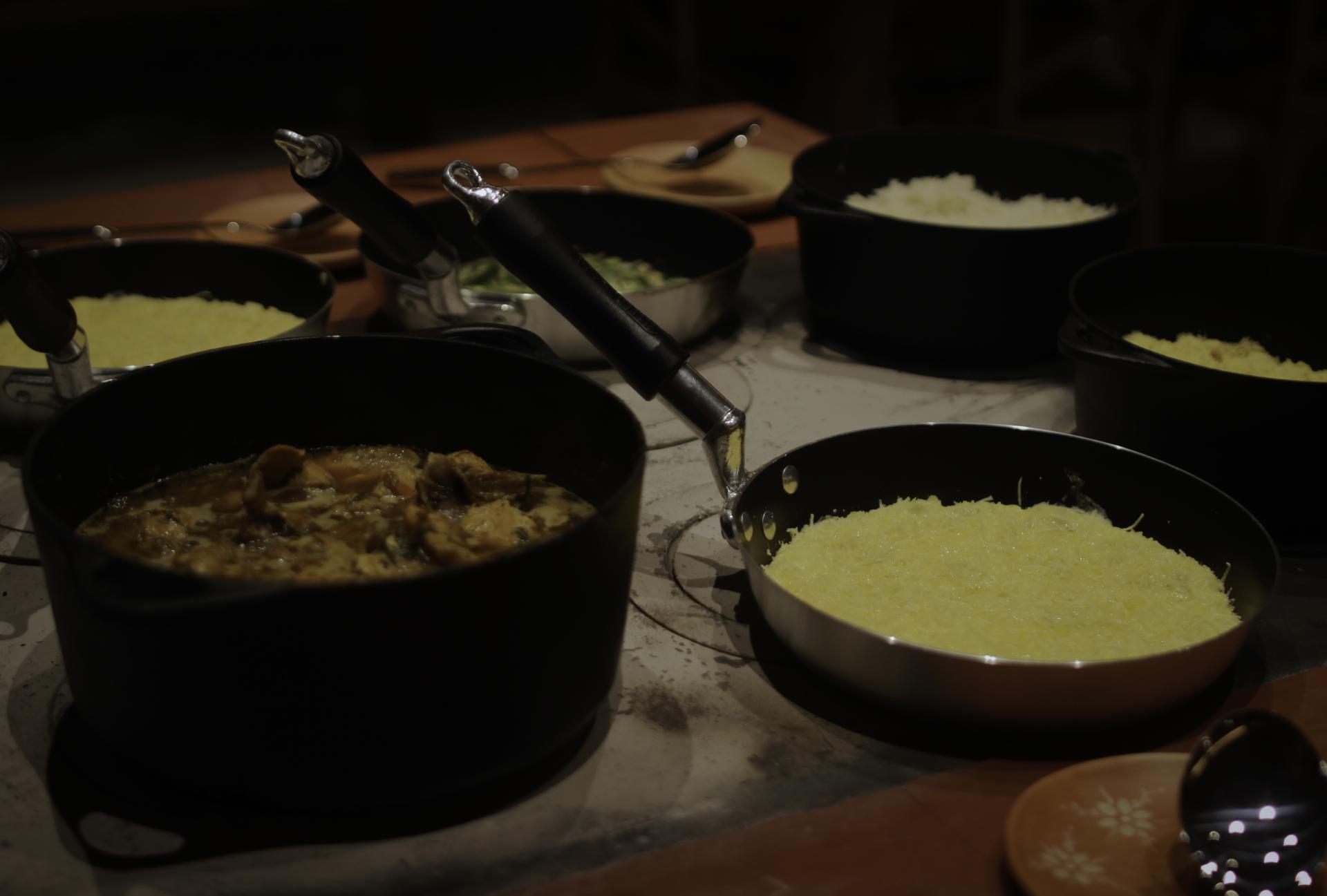 Traditional Brazilian dish served in black pots, accompanied by polenta and other side dishes.